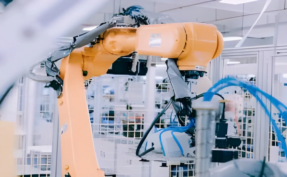 An orange robot arm at work on the production line